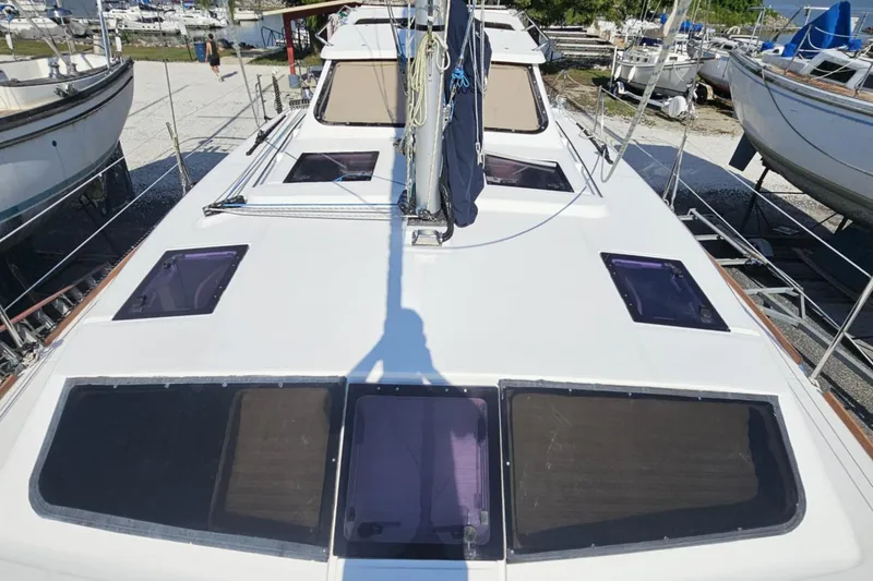 Slide: The Image of 2014 Gemini Legacy 35 catamaran on dry dock, surrounded by trees and vehicles. - 2