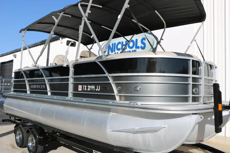 Slide: The Image of 2023 Sylvan Mirage X X3 Party Fish pontoon boat on trailer, parked outside dealership. - 4