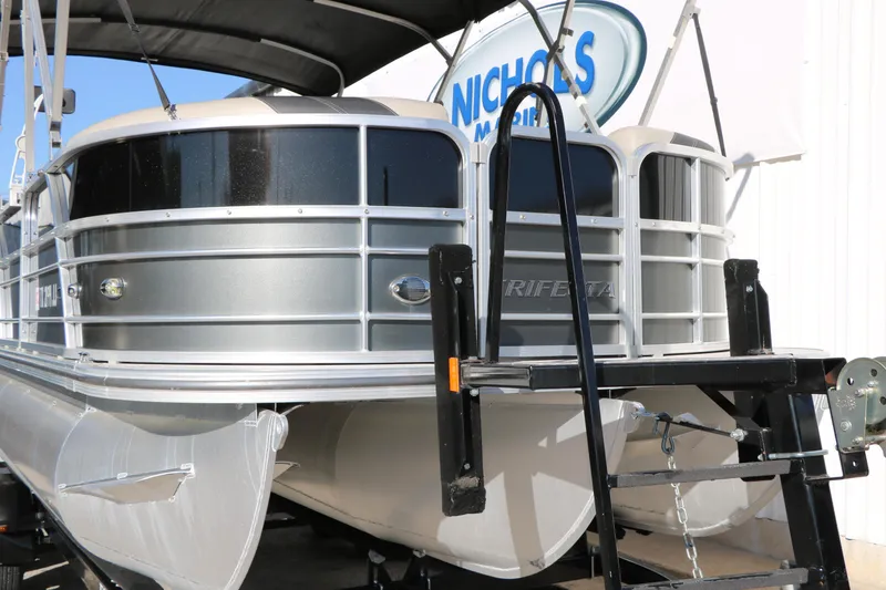 Slide: The Image of 2023 Sylvan Mirage X X3 Party Fish pontoon boat on trailer, front view. - 5