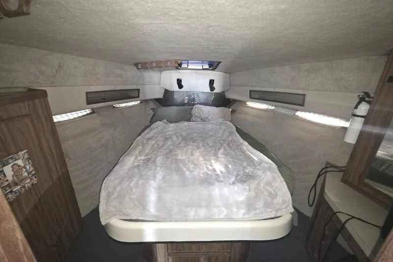 Slide: The Image of 1985 Sea Ray 340 Sedan Bridge cabin interior with bed and wooden cabinetry. - 14