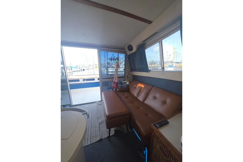Slide: The Image of Interior of 1985 Sea Ray 340 Sedan Bridge with leather seating and marina view. - 7