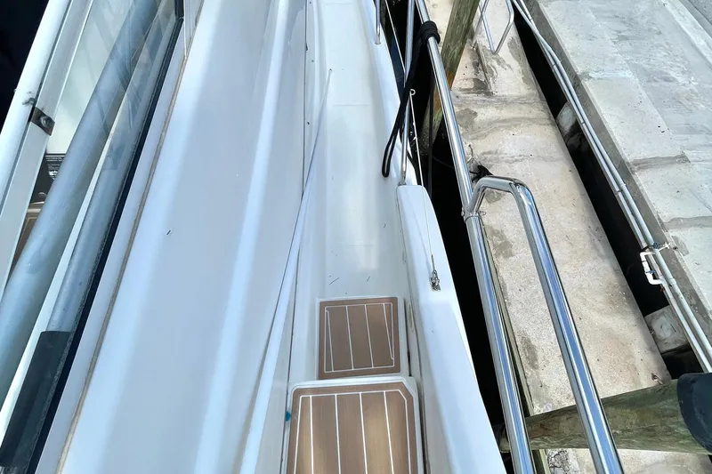 Slide: The Image of 2005 Silverton 43 Sport Bridge yacht docked, showing side deck and railing. - 10