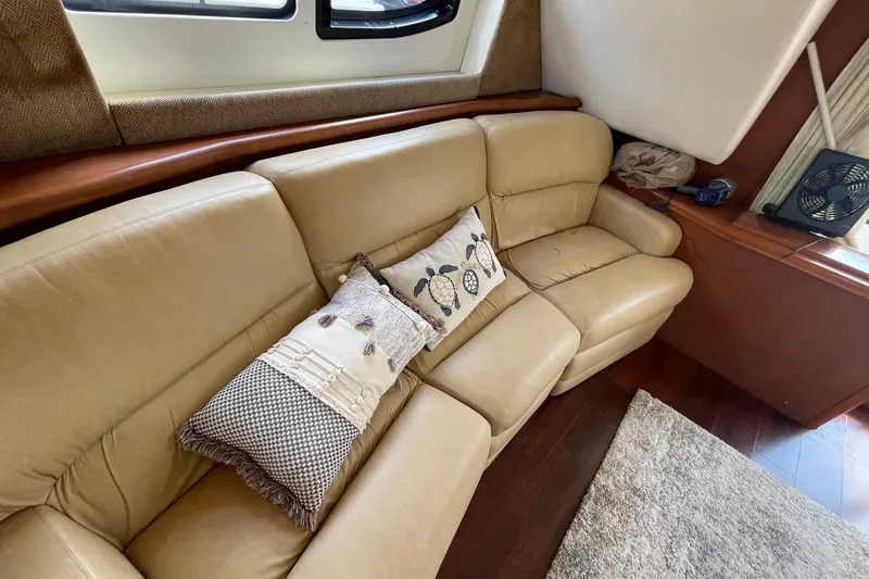 Slide: The Image of Luxurious beige leather sofa with decorative pillows in a 2005 Silverton 43 Sport Bridge yacht. - 14