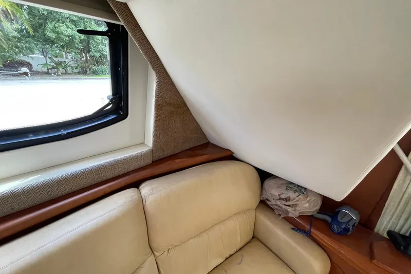 Slide: The Image of 2005 Silverton 43 Sport Bridge interior with beige seating and window view. - 15