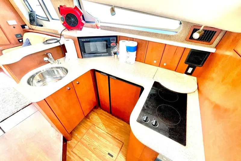 Slide: The Image of 2005 Silverton 43 Sport Bridge yacht kitchen with sink, stove, and microwave. - 19