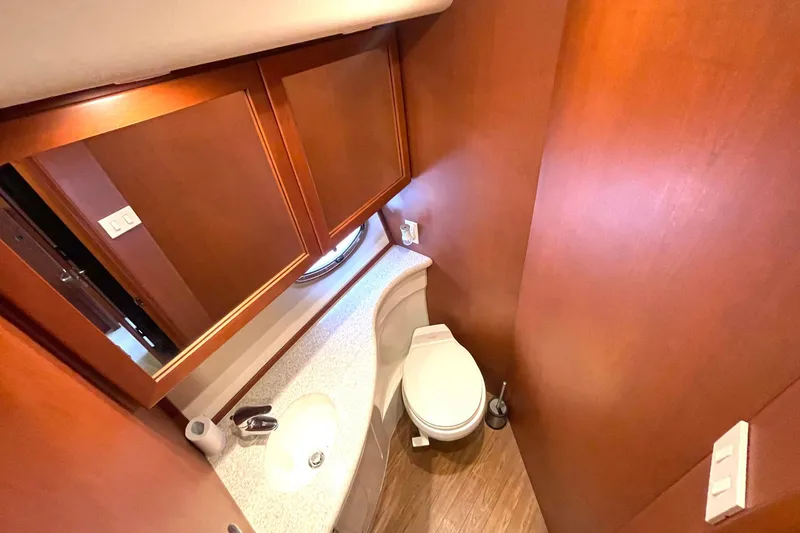 Slide: The Image of 2005 Silverton 43 Sport Bridge bathroom with wooden cabinets and modern fixtures. - 23