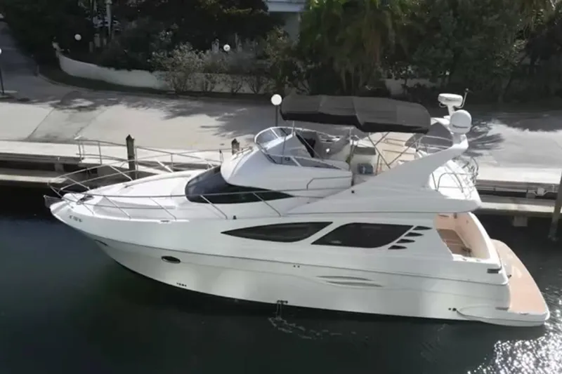 The Image of 2005 Silverton 43 Sport Bridge yacht docked in a serene marina setting. - 3