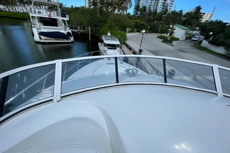 Slide: The Image of 2005 Silverton 43 Sport Bridge yacht docked in a marina, surrounded by lush greenery. - 5