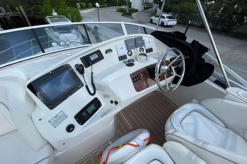 Slide: The Image of 2005 Silverton 43 Sport Bridge helm with modern navigation equipment and steering wheel. - 6