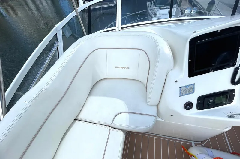 Slide: The Image of 2005 Silverton 43 Sport Bridge interior with white seating and control panel. - 8