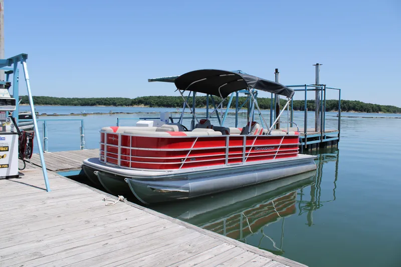 The Image of 2024 Berkshire 24RFX LE pontoon boat docked on a serene lake. - 0