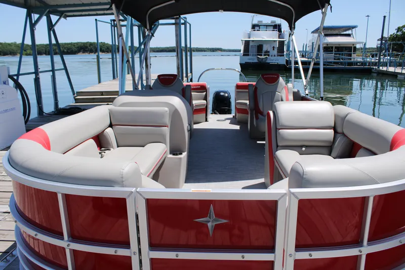 Slide: The Image of 2024 Berkshire 24RFX LE pontoon boat with red and gray seating at a dock. - 4