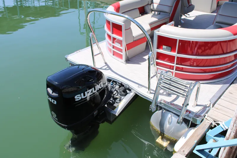 Slide: The Image of 2024 Berkshire 24RFX LE pontoon boat with Suzuki outboard motor on calm water. - 8