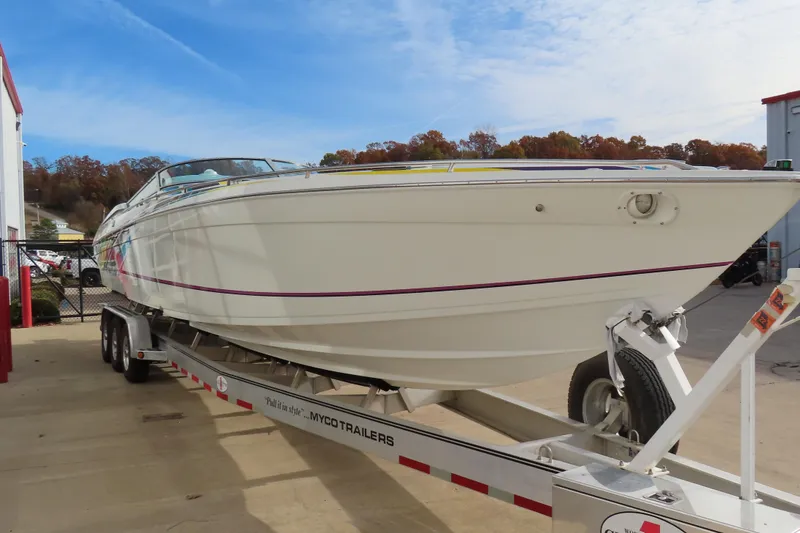 Slide: The Image of 1999 Formula 382 FASTech boat on trailer, parked outdoors, clear sky background. - 2