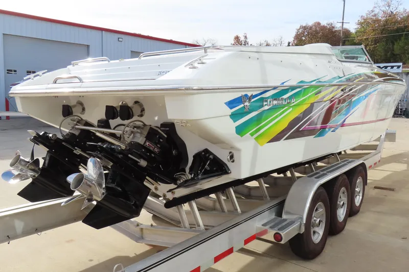 Slide: The Image of 1999 Formula 382 FASTech speedboat on trailer, vibrant graphics, dual propellers, outdoor setting. - 3