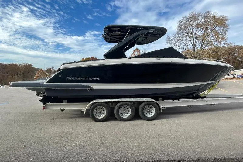 Slide: The Image of 2024 Chaparral 307 SSX boat on trailer, parked outdoors under a blue sky. - 3