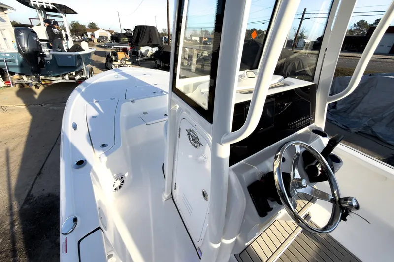 Slide: The Image of 2026 Tidewater 2110 Bay Max boat interior with steering wheel and console, docked outdoors. - 26