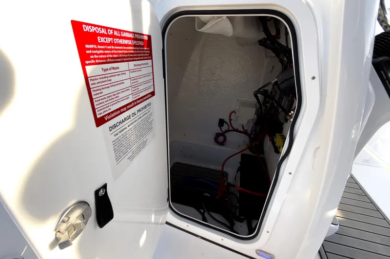 Slide: The Image of Open hatch of 2026 Tidewater 2110 Bay Max boat showing interior wiring and warning label. - 28