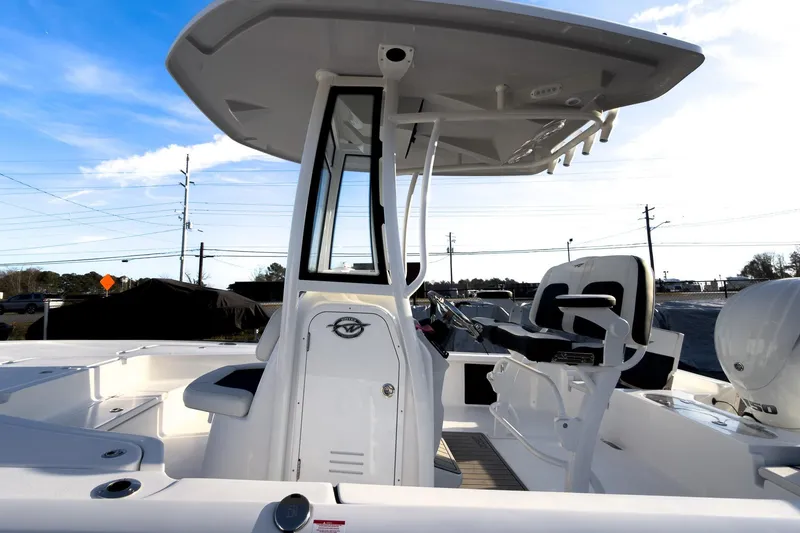 Slide: The Image of 2026 Tidewater 2110 Bay Max boat interior with console and seating, under a clear blue sky. - 30