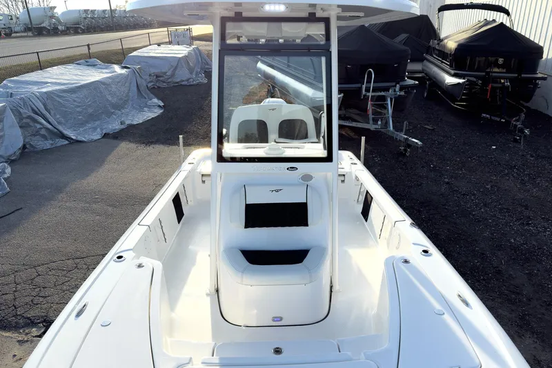 Slide: The Image of 2026 Tidewater 2110 Bay Max boat, white interior, parked outdoors with covered boats nearby. - 39