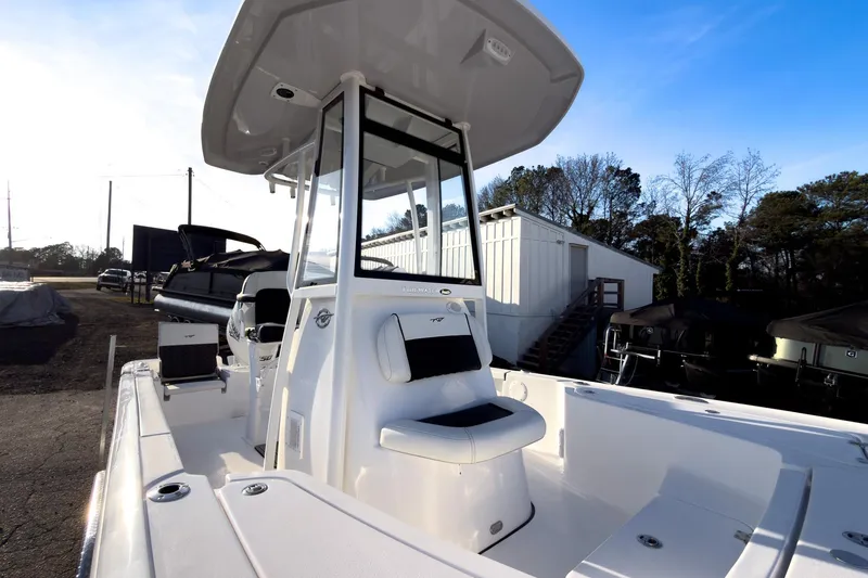 Slide: The Image of 2026 Tidewater 2110 Bay Max boat with T-top and seating, parked outdoors. - 40