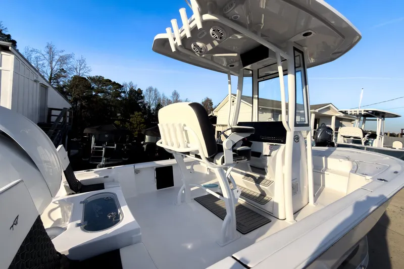 Slide: The Image of 2026 Tidewater 2110 Bay Max boat with T-top and seating, docked outdoors. - 6