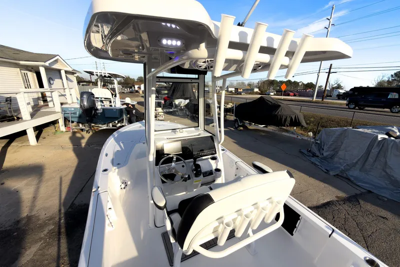 Slide: The Image of 2026 Tidewater 2110 Bay Max boat with T-top and console, parked outdoors. - 7