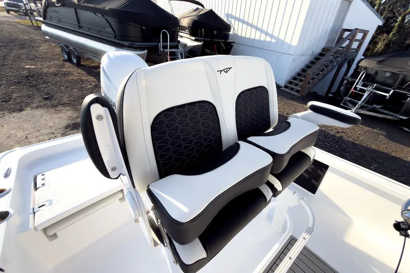 Slide: The Image of 2026 Tidewater 2110 Bay Max boat seats with black and white design, docked outdoors. - 9