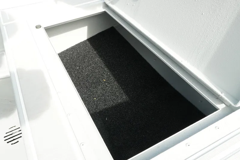 Slide: The Image of Open storage compartment in 2026 G3 Bay 19 GX boat, featuring black interior lining. - 25