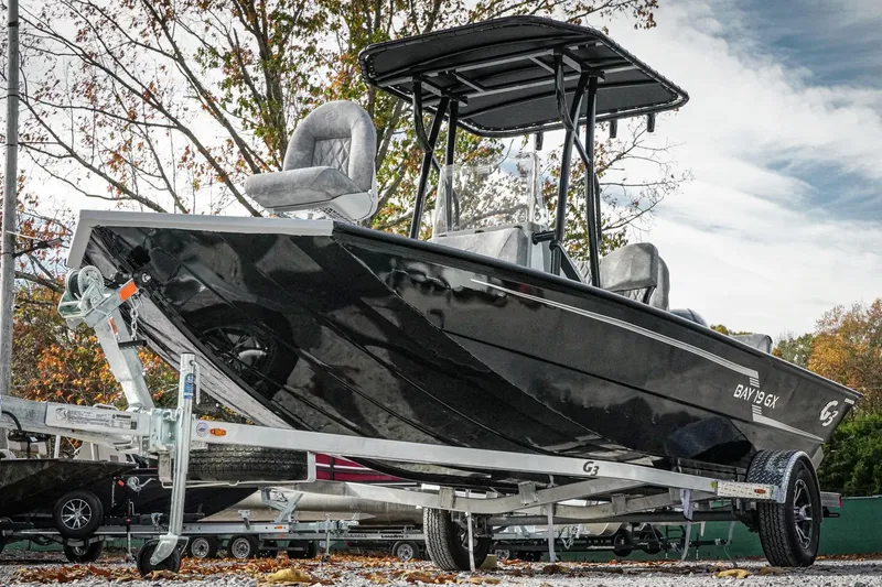 Slide: The Image of 2026 G3 Bay 19 GX boat on trailer, sleek black design, outdoor setting. - 6