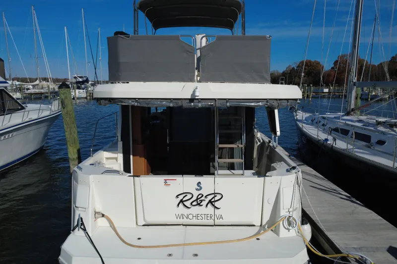 Slide: The Image of 2023 Beneteau Swift Trawler 35 docked at marina, rear view with name "R&R". - 10