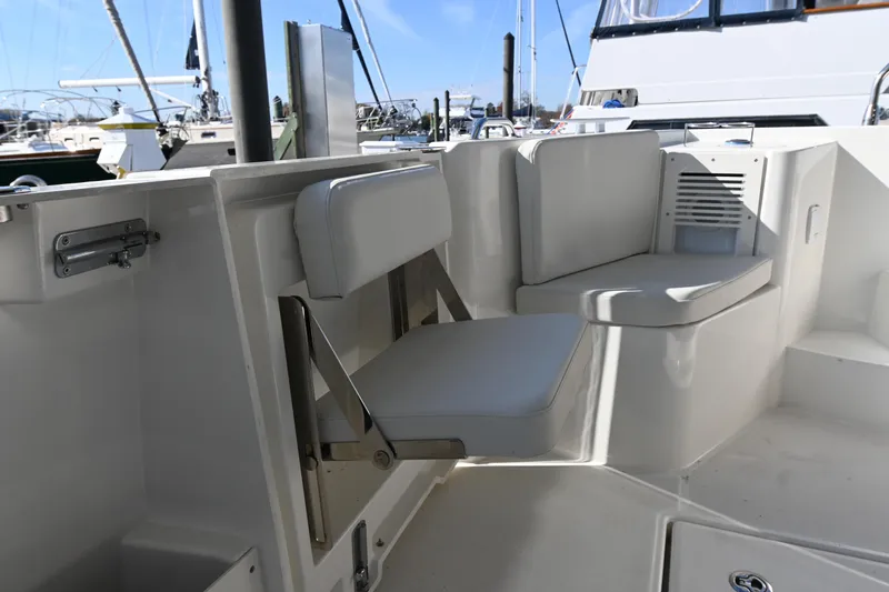 Slide: The Image of 2023 Beneteau Swift Trawler 35 interior seating area with white cushions. - 12