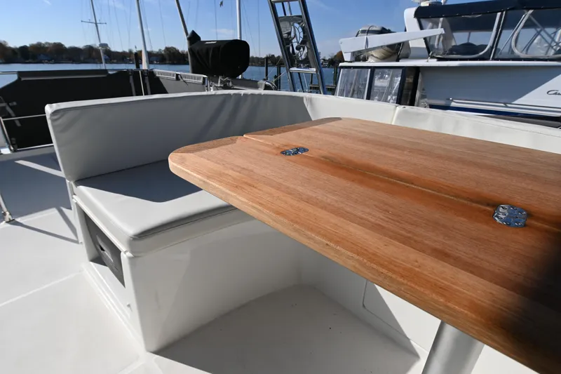 Slide: The Image of 2023 Beneteau Swift Trawler 35 deck with wooden table and cushioned seating. - 22