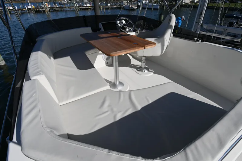 Slide: The Image of 2023 Beneteau Swift Trawler 35 flybridge with seating and wooden table, docked at marina. - 23