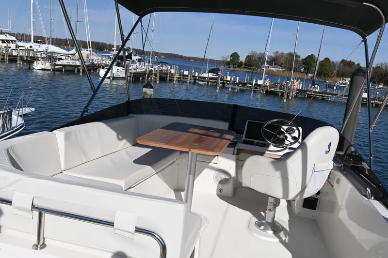 Slide: The Image of Flybridge of 2023 Beneteau Swift Trawler 35 with seating and helm, docked at marina. - 24