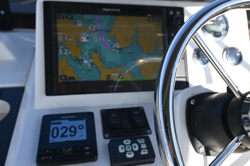 Slide: The Image of 2023 Beneteau Swift Trawler 35 helm with navigation display and steering wheel. - 26
