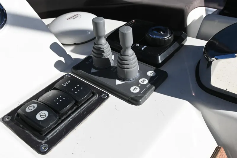 Slide: The Image of Control panel of 2023 Beneteau Swift Trawler 35 with switches and joysticks. - 27