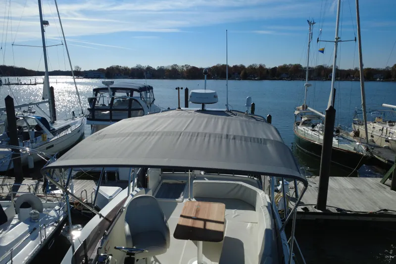 Slide: The Image of 2023 Beneteau Swift Trawler 35 docked at marina, surrounded by sailboats. - 30
