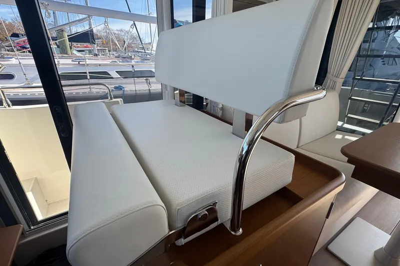 Slide: The Image of Interior of 2023 Beneteau Swift Trawler 35 with white seating and marina view. - 36