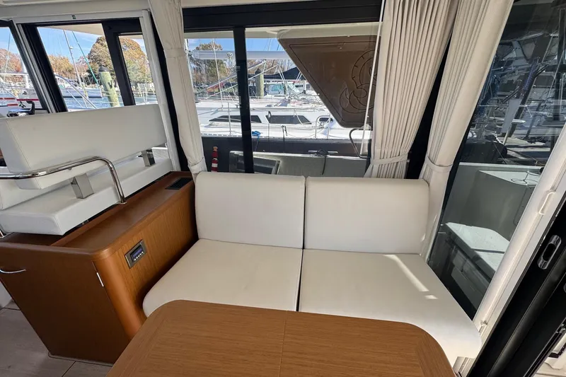 Slide: The Image of Interior of 2023 Beneteau Swift Trawler 35 with white seating and marina view. - 37