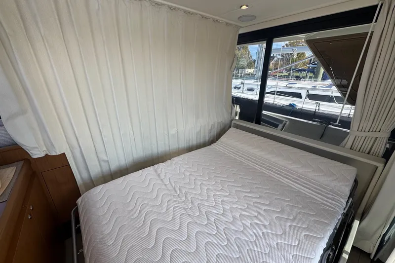 Slide: The Image of 2023 Beneteau Swift Trawler 35 interior cabin with bed and window view. - 39
