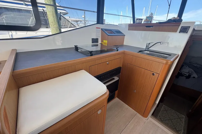 Slide: The Image of 2023 Beneteau Swift Trawler 35 interior kitchen with modern amenities and wooden cabinetry. - 4