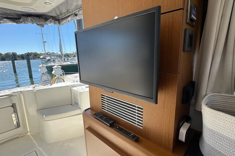 Slide: The Image of Interior of 2023 Beneteau Swift Trawler 35 with TV and marina view. - 40