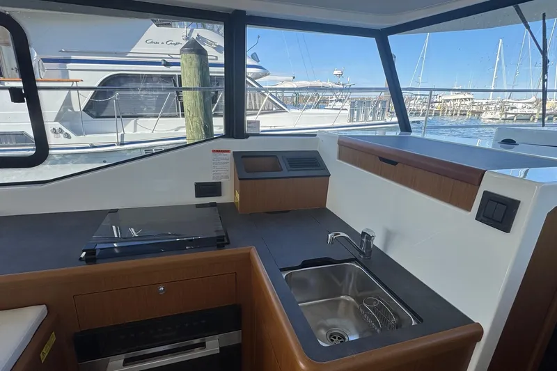 Slide: The Image of 2023 Beneteau Swift Trawler 35 interior kitchen with sink and stove, marina view. - 43