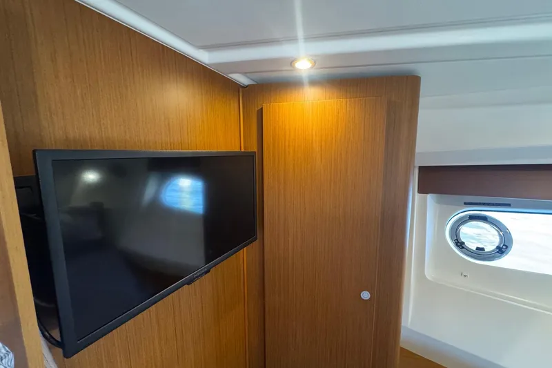 Slide: The Image of 2023 Beneteau Swift Trawler 35 interior with TV and porthole window. - 47