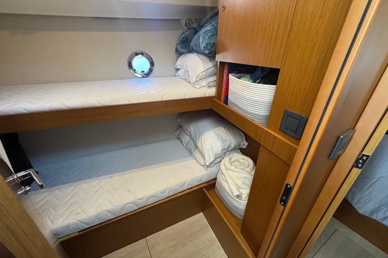 Slide: The Image of 2023 Beneteau Swift Trawler 35 cabin with bunk beds and storage shelves. - 54