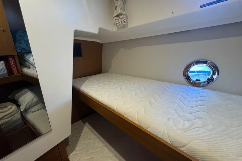 Slide: The Image of Cozy cabin interior of 2023 Beneteau Swift Trawler 35 with porthole and storage. - 55