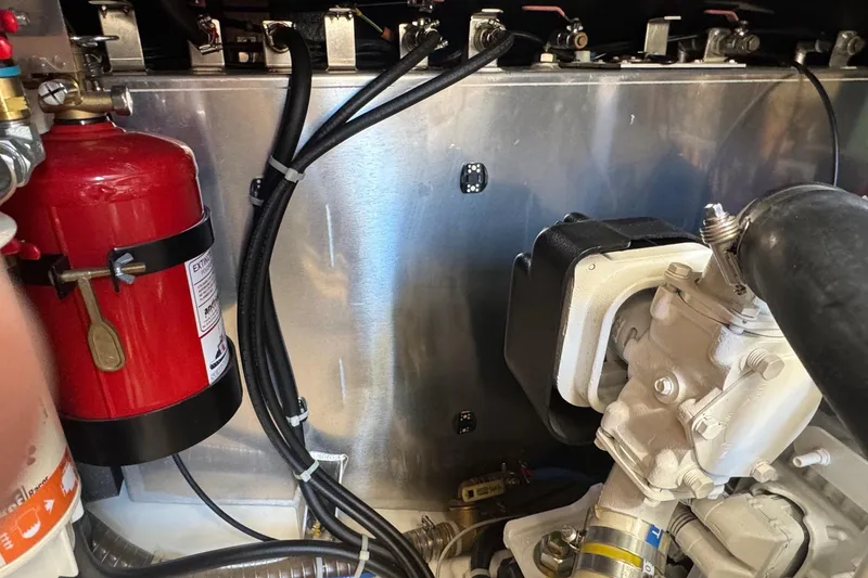 Slide: The Image of Engine room of 2023 Beneteau Swift Trawler 35 with fire extinguisher and mechanical components. - 59