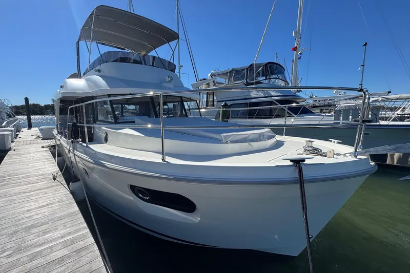 Slide: The Image of 2023 Beneteau Swift Trawler 35 docked at marina under clear blue sky. - 7