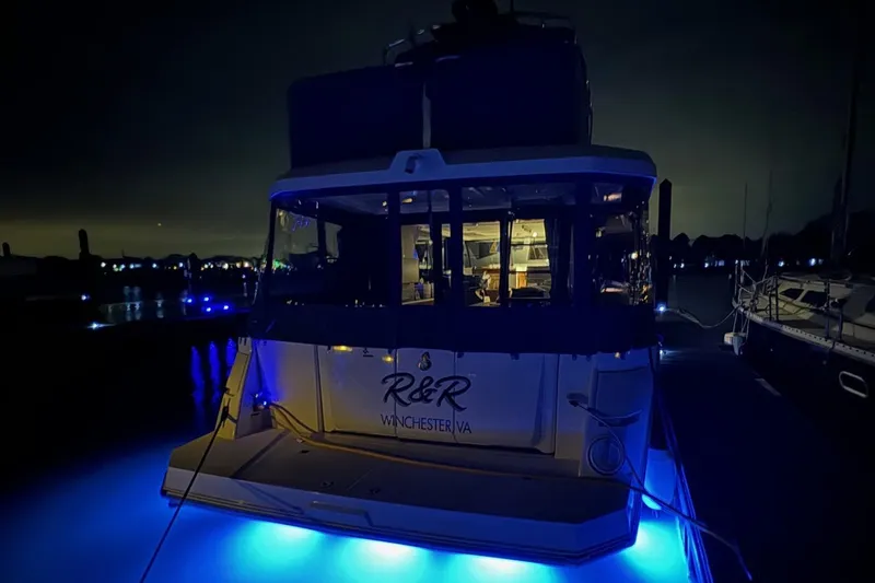Slide: The Image of 2023 Beneteau Swift Trawler 35 with blue underwater lights at night. - 9